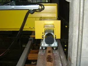 Mecanismo de translação amarelo sobre trilho de ponte rolante